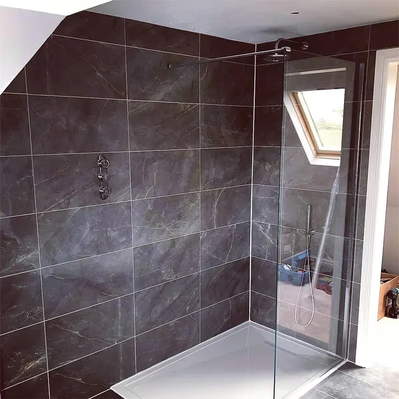 Walk in shower with dark marble effect tiling, a rainfall shower head and a glass screen, installed by Heritage Heating Services